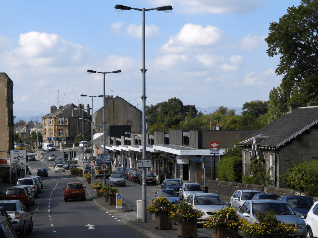 A pleasant suburban high street in Clarkston, Glasgow with independent shops and trees - Oracle Law Glasgow